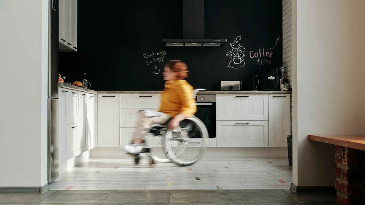 Rollstuhlfahrerin in Küche