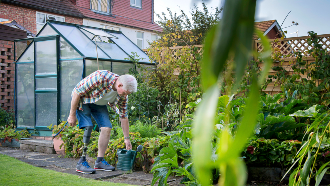 Mann mit Beinprothese im Garten