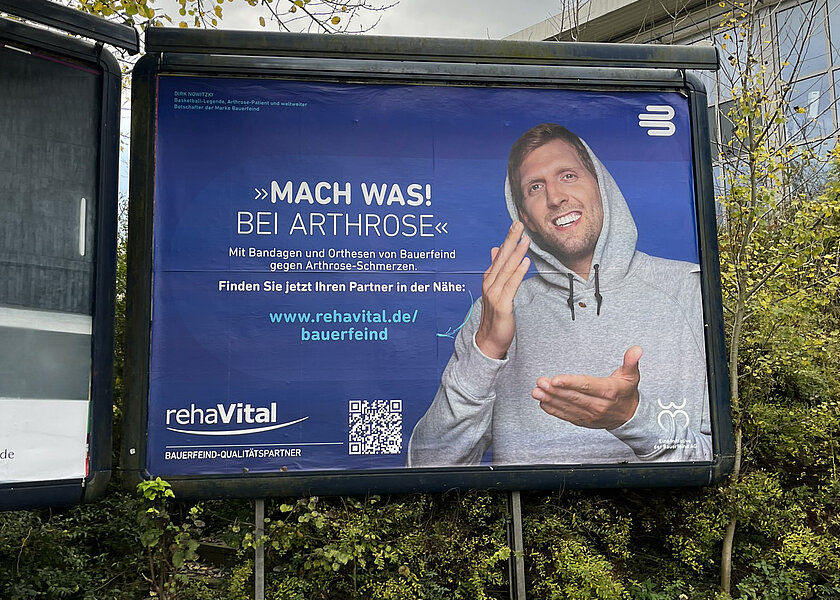 Foto einer Plakatwand mit dem Kampagnenmotiv von rehaVital und Bauerfeind
